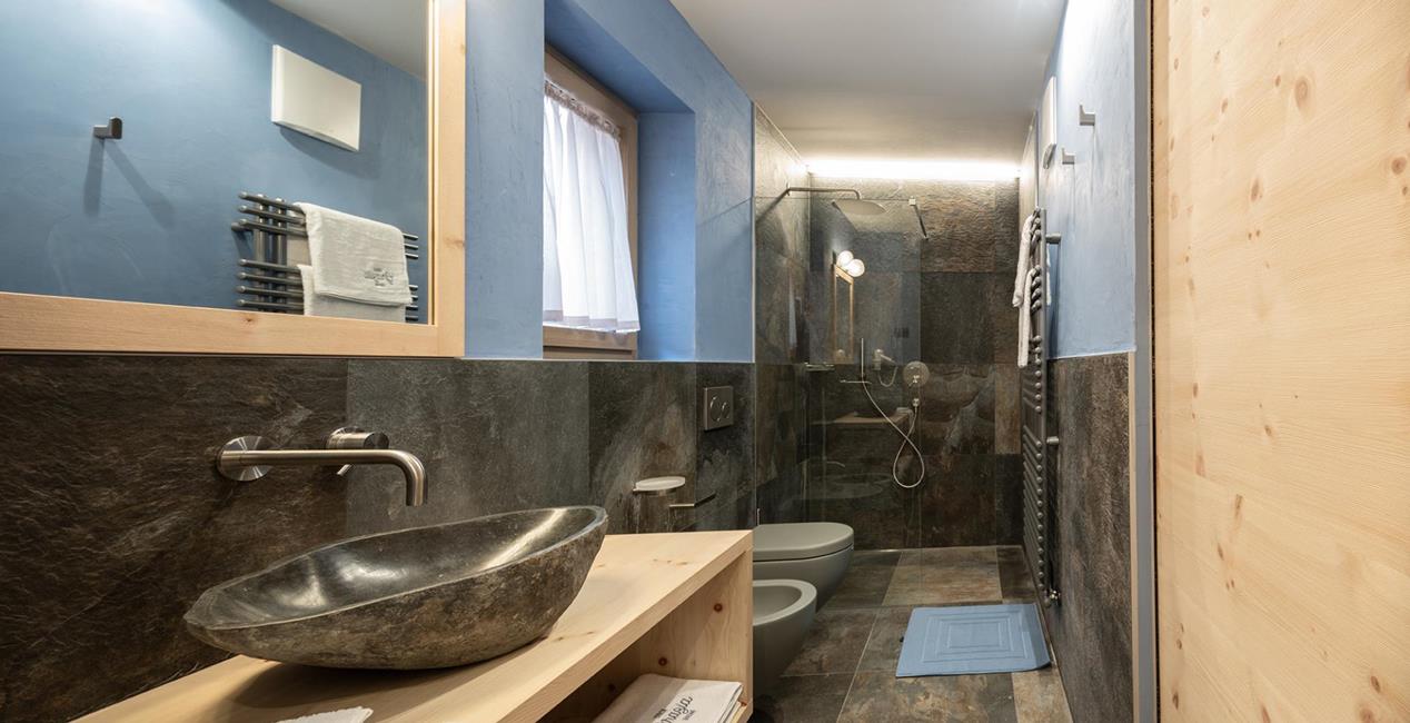 Eines der Badezimmer von Ciasa Grazia mit Dusche, Waschtisch, Bidet und WC