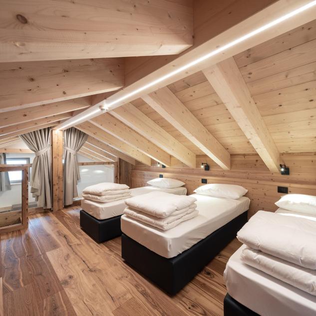 Die Schlafmöglichkeit unter dem Dach mit drei Einzelbetten von Ciasa Grazia