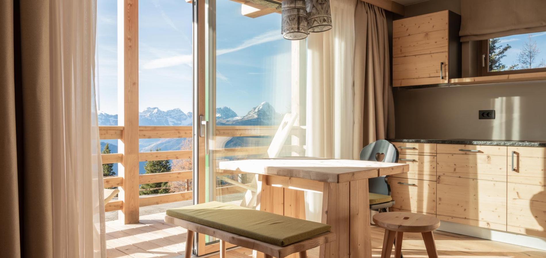 Living area of a chalet with balcony and kitchenette