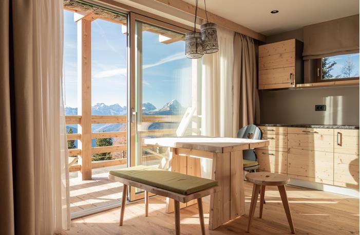 Living area of a chalet with balcony and kitchenette